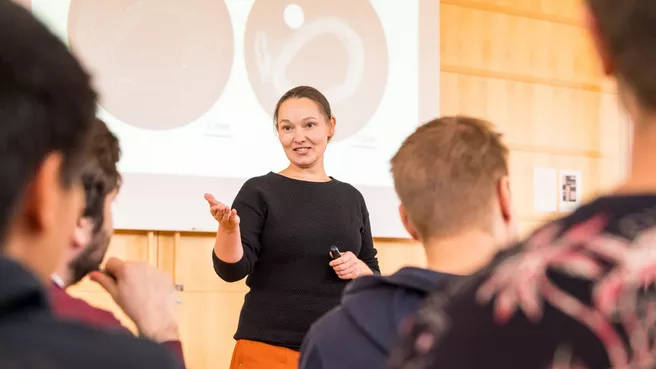Bild zeigt Frau, die Vortrag hält und verlinkt zu den Weiterbildungsangeboten und Veranstaltungen von TUM Patente und Lizenzen